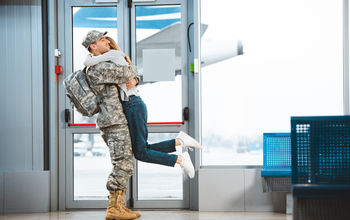 Woman greets military spouse at airport. 