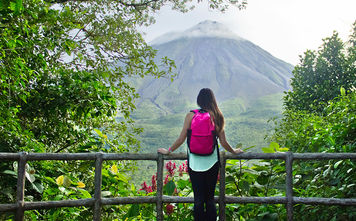 Hiker looking out at the Arenal volcano in La Fortuna