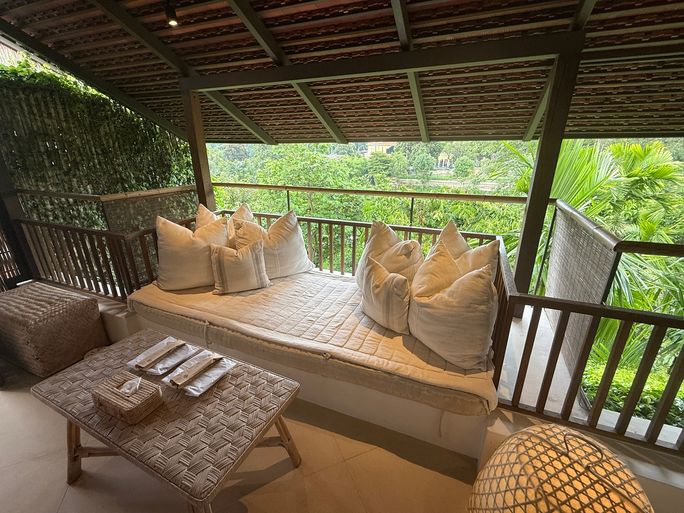 The spacious balcony in a Huen Bon Suite at Raya Heritage overlooks the lush grounds and Ping River, facing east for sunrise views.