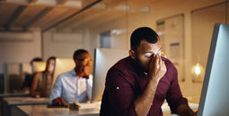 Burnt-out office worker in front of his laptop.