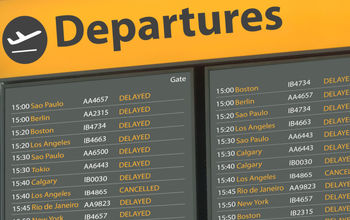 Airport departure board with delayed flights.