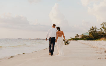 Newlywed couple walking down the beach