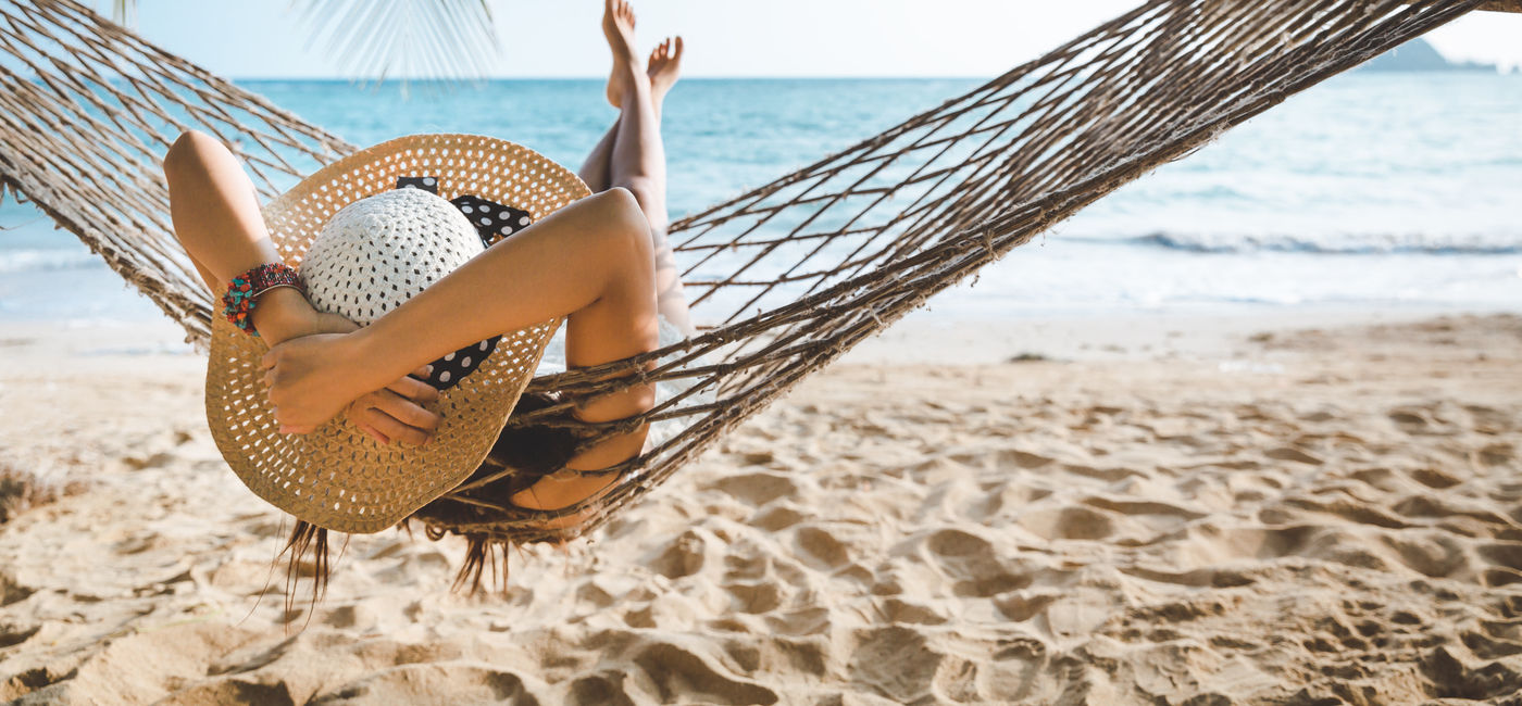 Image: Summer traveler relaxing on the beach. (Photo Credit: Peera/Adobe)