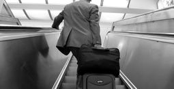 Business traveler suitcase escalator airport