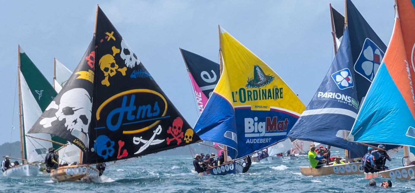 Image: Les voiliers, ou « kanottes », en lice pour la première place lors de la sixième étape de la course entre Baie-Mahault et Sainte-Rose (Photo Credit: Bert Archer)