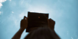Person watching the solar eclipse through an eclipse viewer. 