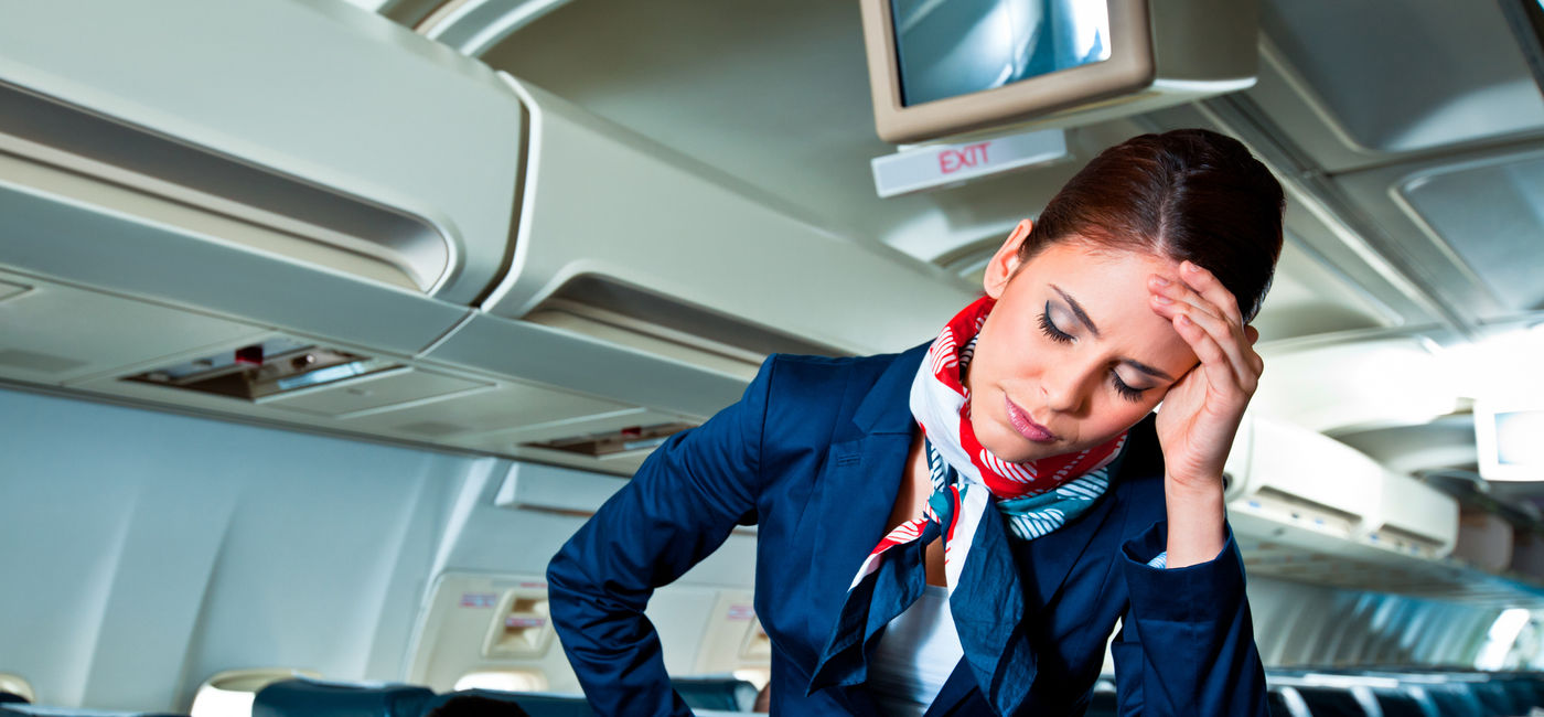 Image: An exhausted and frustrated flight attendant. (photo via iStock/Getty Images E+/izusek)