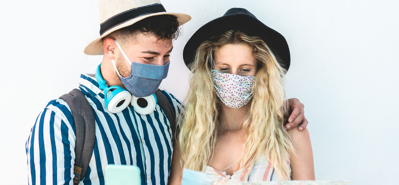 Image: Young couple examining a map while vacationing amid COVID-19. (photo via iStock/Getty Images Plus/Disobey Art)