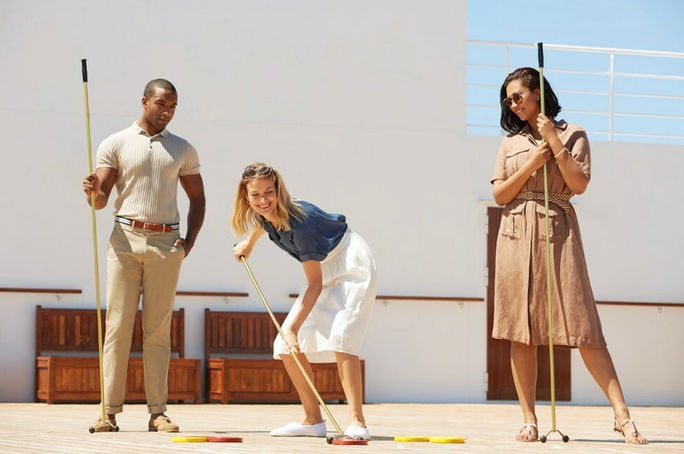 Gäste spielen Shuffleboard auf einer Cunard-Kreuzfahrt Gäste spielen Shuffleboard auf einer Cunard-Kreuzfahrt