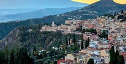 The town of Taormina in Sicily, Italy, with Mount Etna visible in the distance.