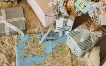 Toy airplane sitting on a map surrounded by holiday gifts.