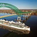 A ship passes under a bridge.