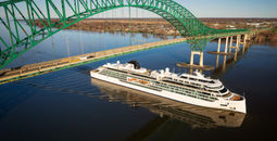 A ship passes under a bridge.