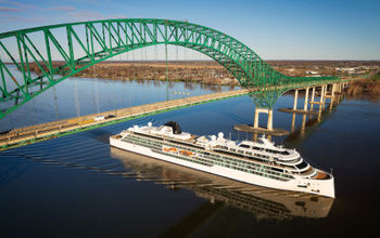 A ship passes under a bridge.