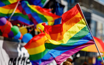 LGBTQI+ flag being waved at a pride parade.