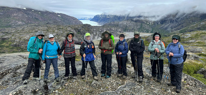 An Adventures in Good Company group poses together in scenic Greenland. Adventures in Good Company, all-women tours, women-only tours, greenland, greenland tours