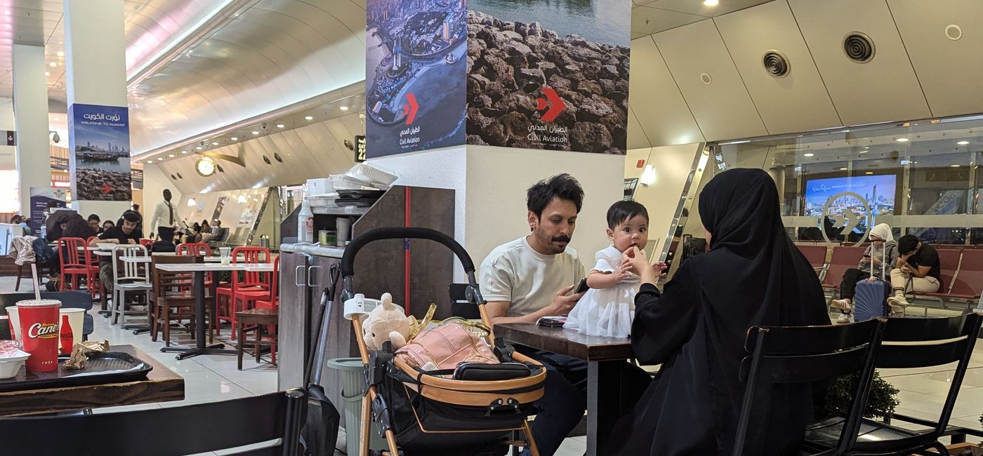 Image: Une famille dîne à l'aéroport de Koweït en 2024 (Photo Credit: Bert Archer)