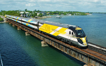 Bright Blue, one of Brightline&#39;s eco-friendly trains, on a bridge in south Florida.