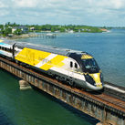 Bright Blue, one of Brightline&#39;s eco-friendly trains, on a bridge in south Florida.