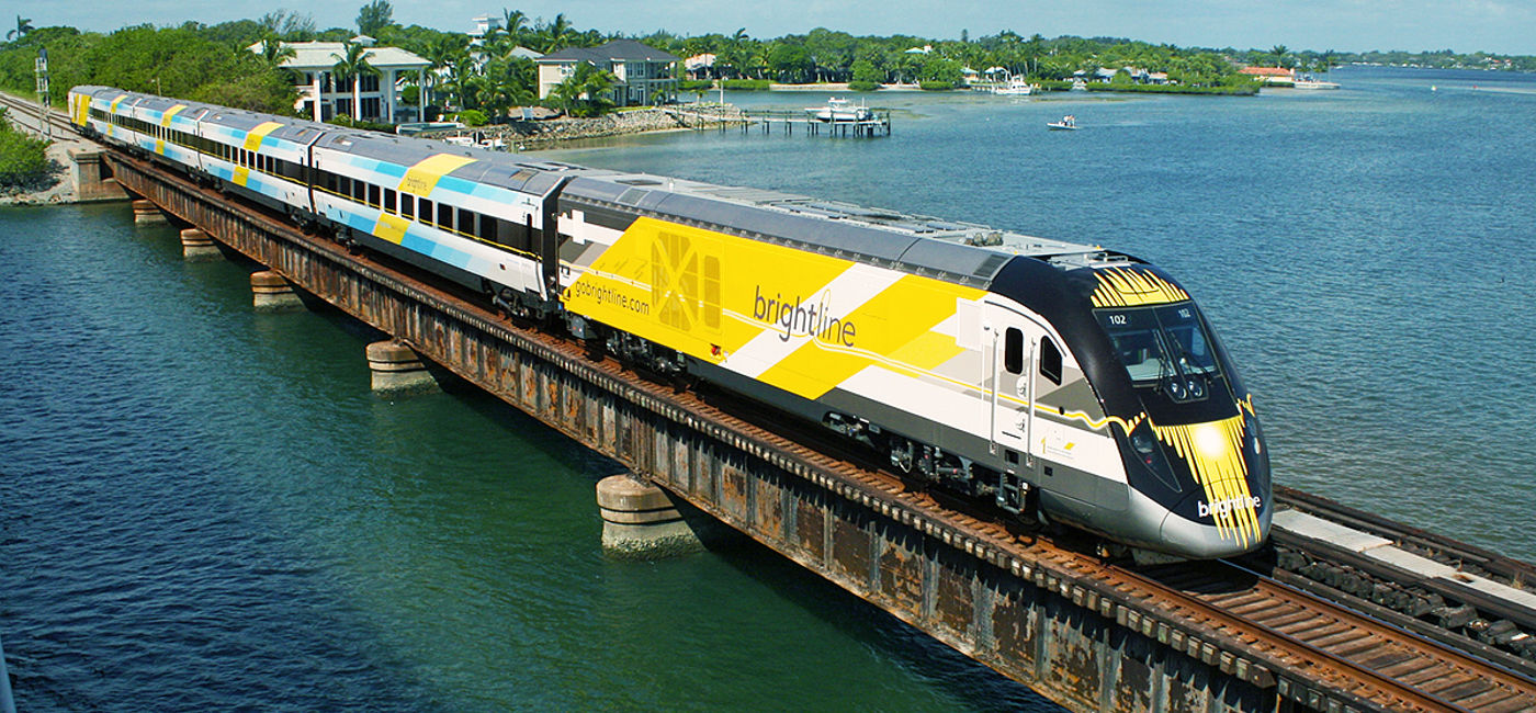 Image: Bright Blue, one of Brightline's eco-friendly trains, on a bridge in south Florida. (photo via Brightline) (Photo Credit: (photo via Brightline))