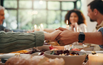 Hands across dinner table