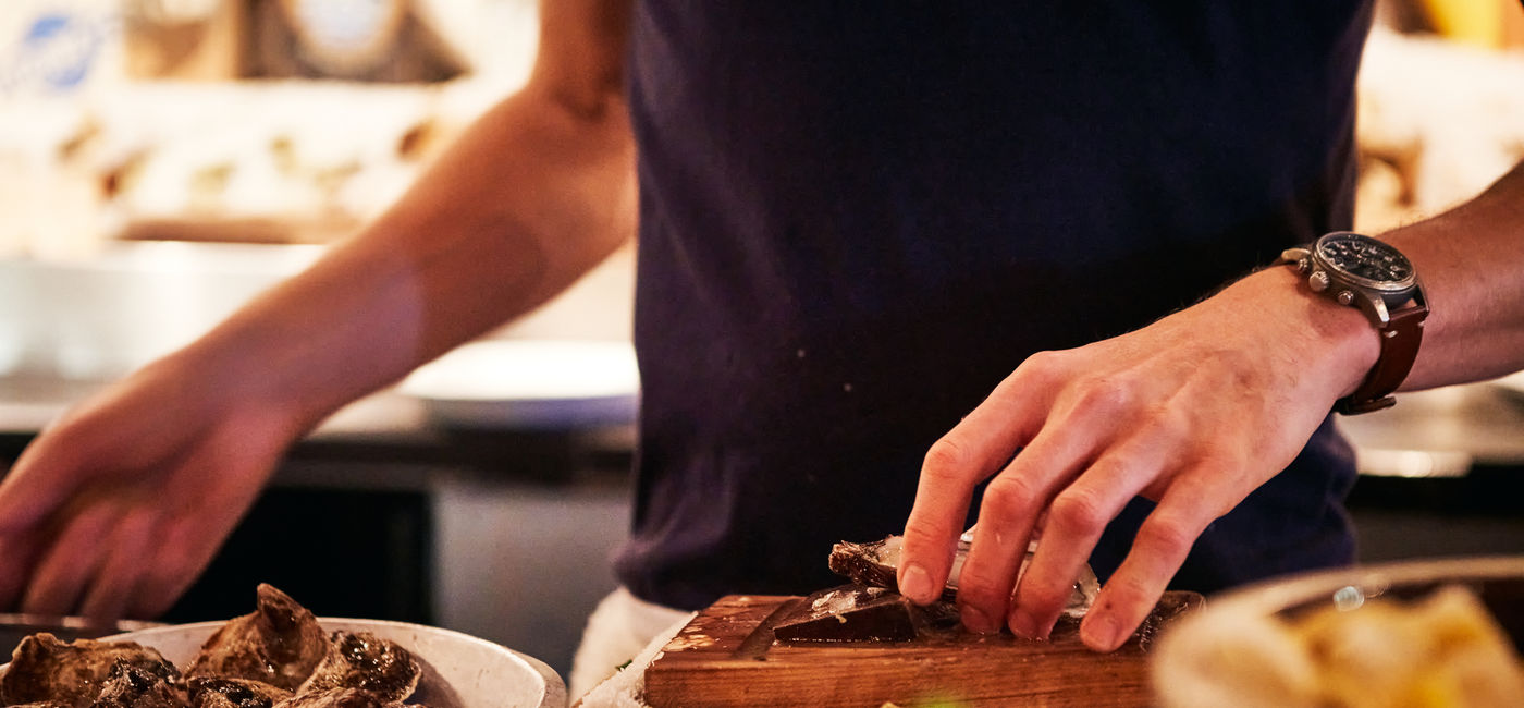 Image: Restaurant worker preparing oysters in Vancouver. (Photo Credit: Adobe/Gary)
