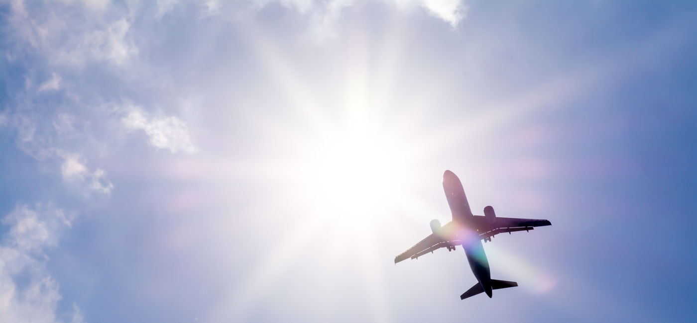 Image: Plane flying through clouds. (Photo Credit: denklim / Adobe Stock)