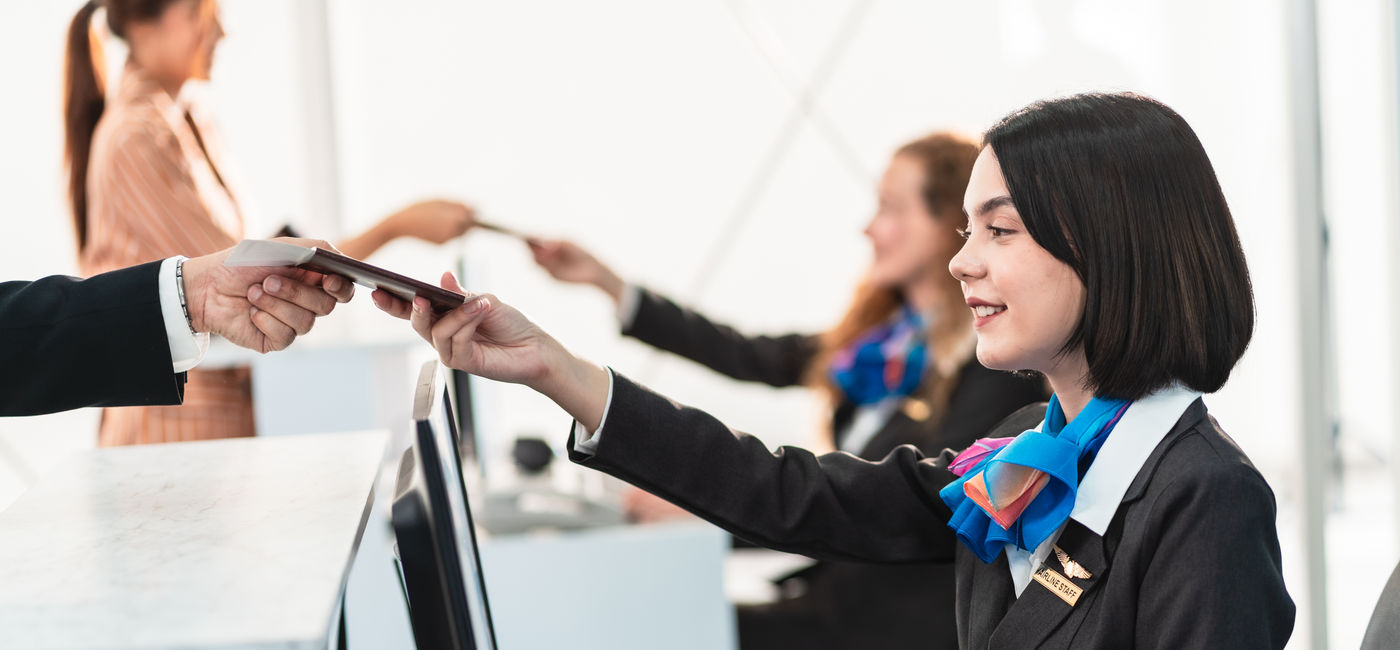 Image: Traveler getting airline tickets. (Photo Credit: Burin / Adobe Stock)