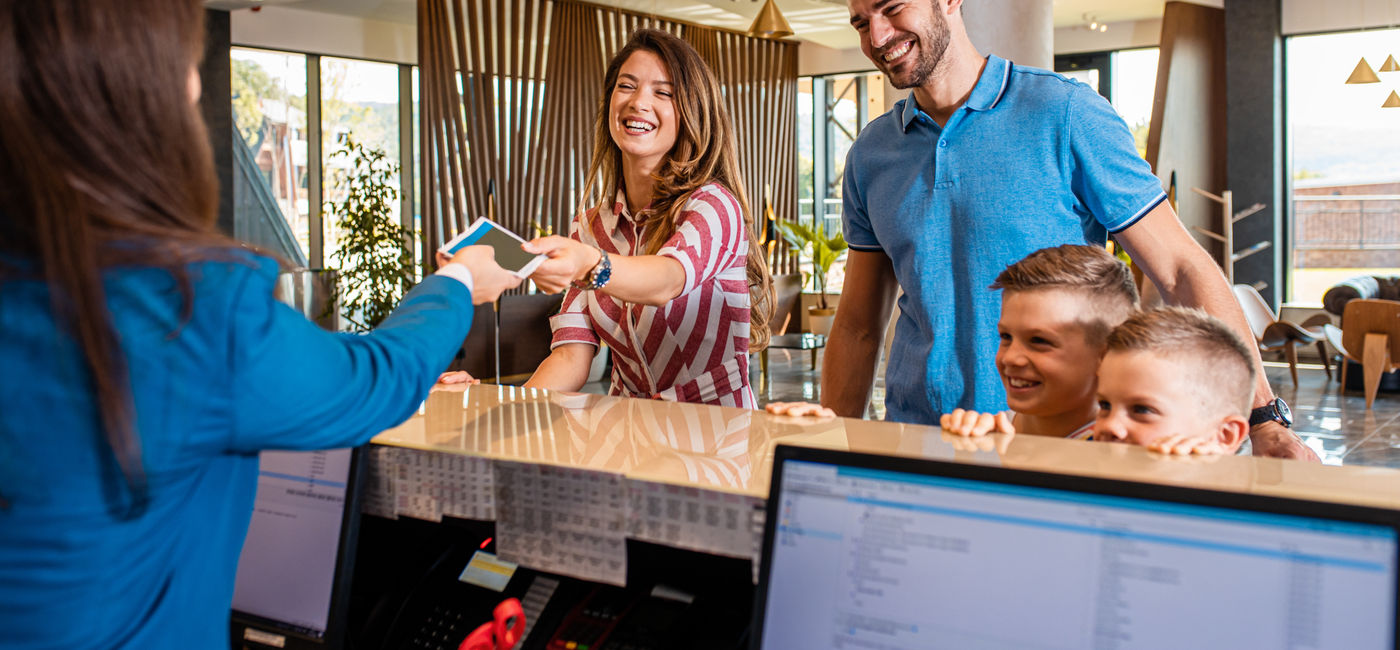 Image: A family checks into a hotel. (Photo Credit: Courtesy AdobeStock)