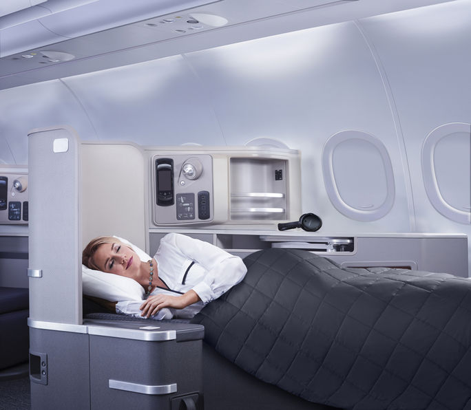 Passagier von American Airlines nutzt Liegesitz der First Class Passagier von American Airlines nutzt Liegesitz der First Class