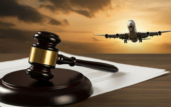 A gavel rests on legal documents with an airplane in the background, symbolizing aviation law and justice in the airline industry.