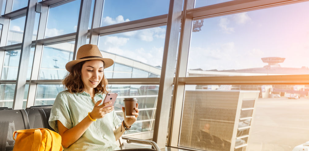 Traveler using her phone at the airport
