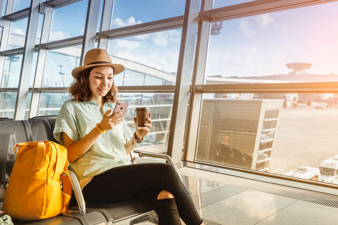 Traveler using her phone at the airport Traveler using her phone at the airport