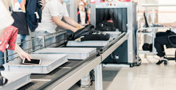Travelers passing through a TSA Airport Security scanning system.