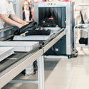 Travelers passing through a TSA Airport Security scanning system.