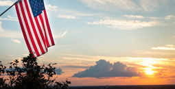 Bright american flag flying above beautiful sunset over Mississippi river