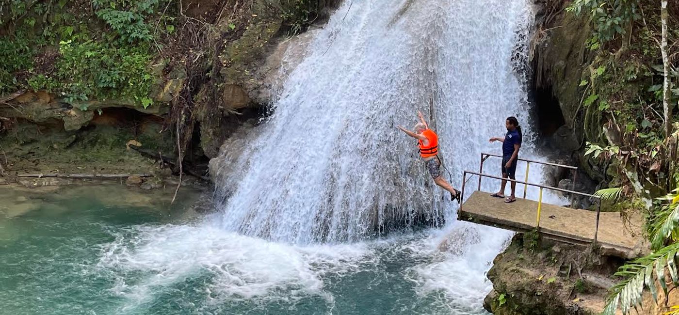Image: Leaping off a cliff into the Island Gully Falls Blue Hole in Ocho Rios. (Photo Credit: Theresa Norton)