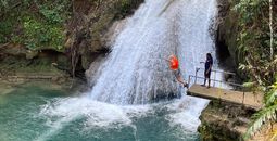 Leaping off a cliff into the Island Gully Falls Blue Hole in Ocho Rios.