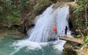Leaping off a cliff into the Island Gully Falls Blue Hole in Ocho Rios.
