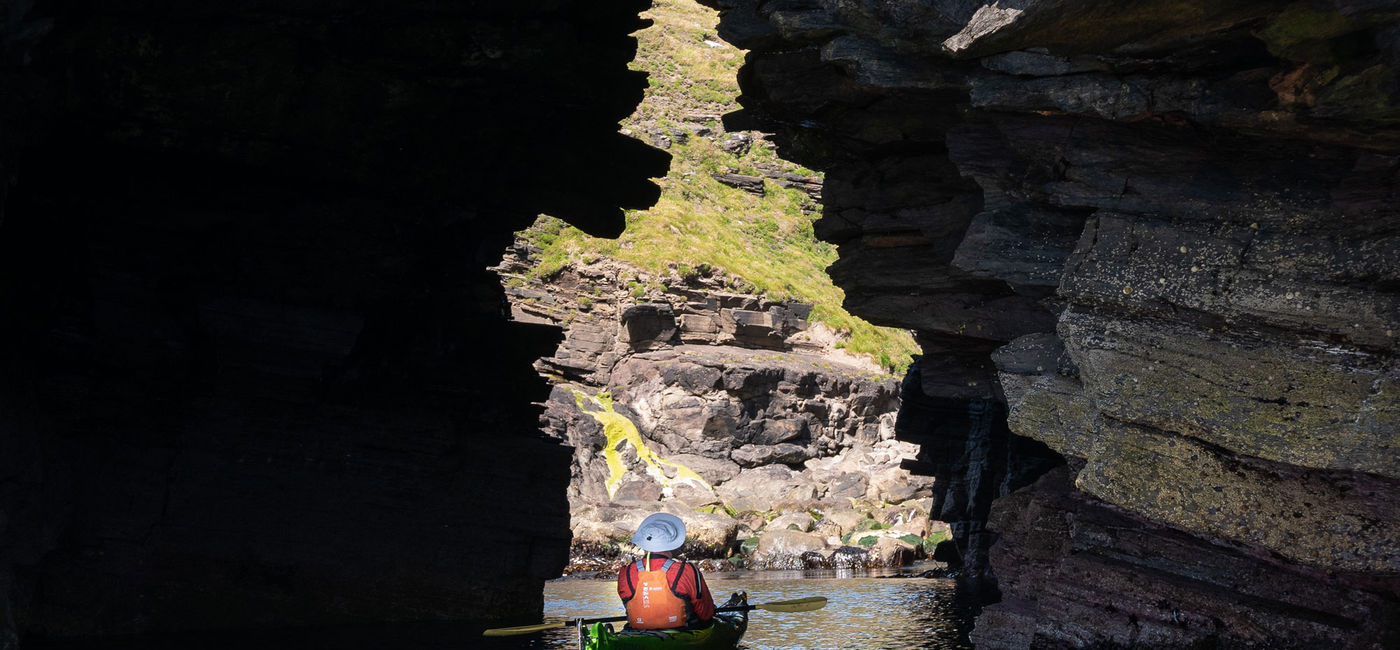 Image: Un kayakiste de mer traverse une grotte en Écosse (Source: (photo via Aurora Expeditions))