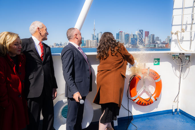 Godmother Emily Coleman, daughter of John and Claudette Waggoner, breaking a bottle of Crown Royal Canadian Whisky on the ship’s bow Godmother Emily Coleman, daughter of John and Claudette Waggoner, breaking a bottle of Crown Royal Canadian Whisky on the ship’s bow