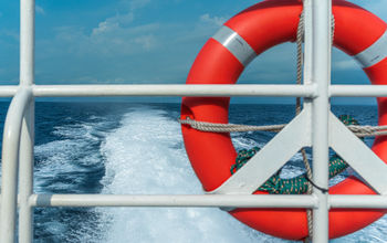 Life preserver secured to a ship's metal railing.