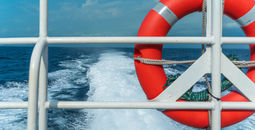 Life preserver secured to a ship's metal railing.