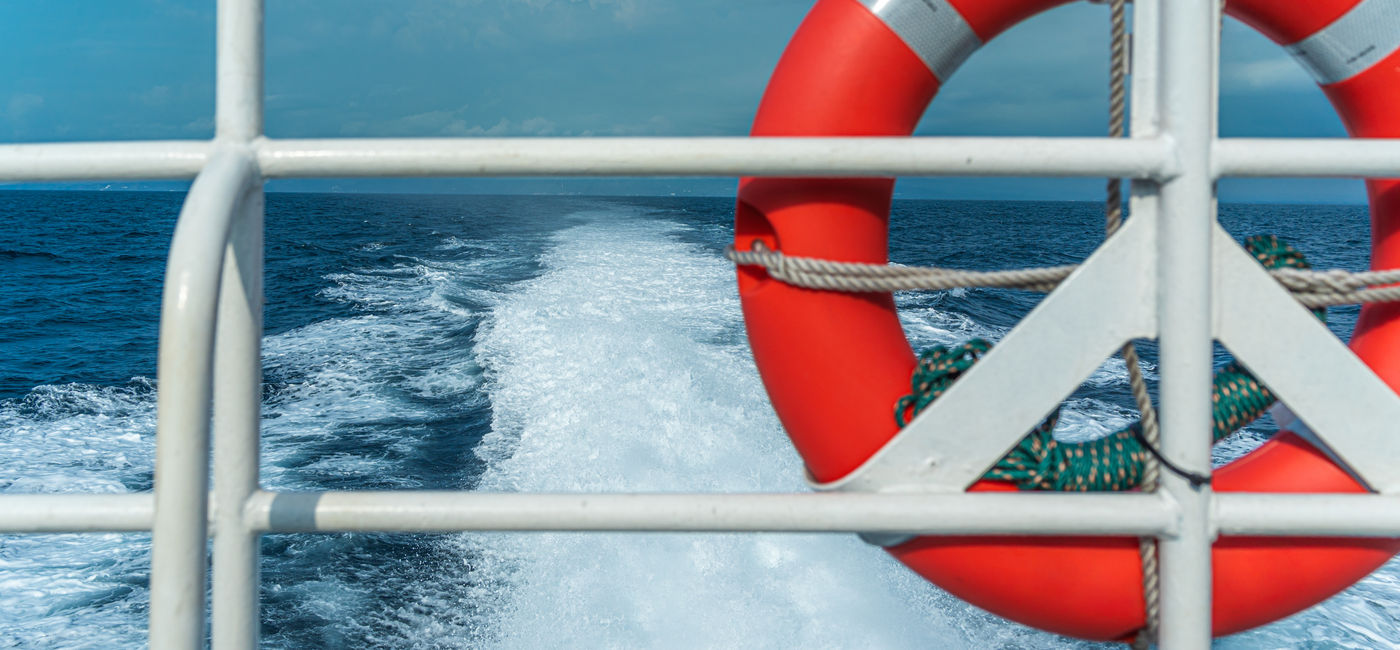 Image: Life preserver secured to a ship's metal railing. (Photo Credit: Adobe Stock/Andik)