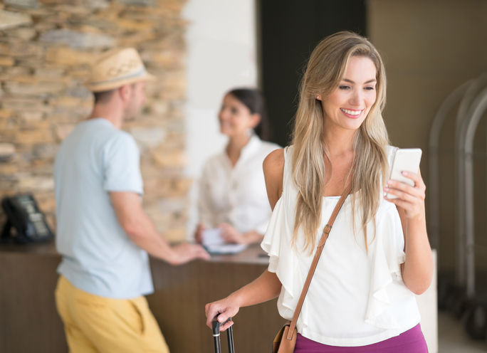 Reisender checkt mit mobiler App im Hotel ein. Reisender checkt mit mobiler App im Hotel ein.