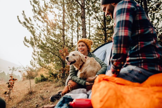 A couple camping with their dog A couple camping with their dog