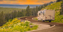 RV driving down rural road.