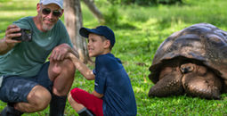 Family taking a picture with a giant tortoise