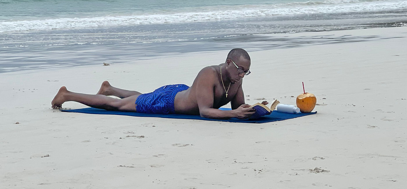 Image: An LGBTQ cruise passenger lounges on Cote D’Or beach in the Seychelles. (Photo Credit: Paul J. Heney)