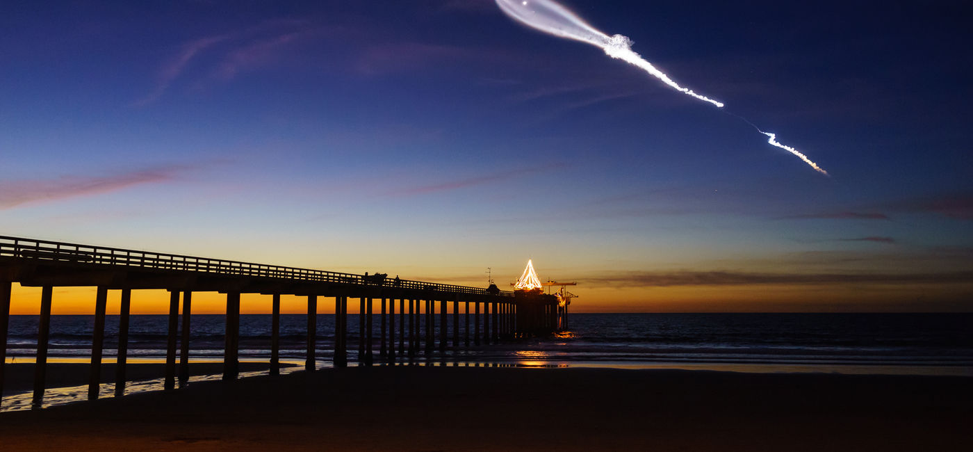 Image: SpaceX launch vehicle Falcon 9 rockets through the atmosphere Scripps Pier in San Diego, California. (Photo Credit: Adobe Stock/Binzhong)